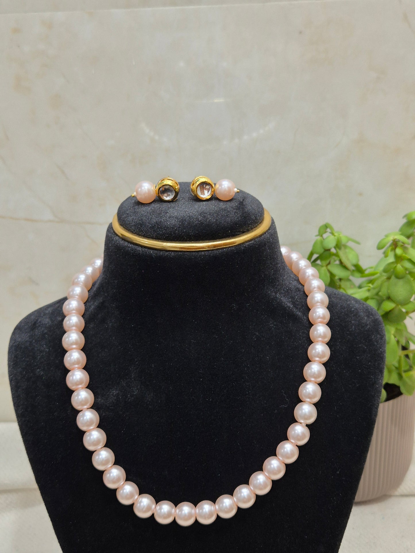 Round light pink pearl necklace set with soft, glossy sheen